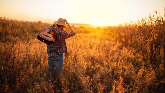 12 songs to make your crops grow taller - man in a field with a guitar