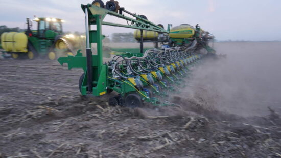 Farm tractor engaged in winter operations, ploughing snow during heavy snowfall